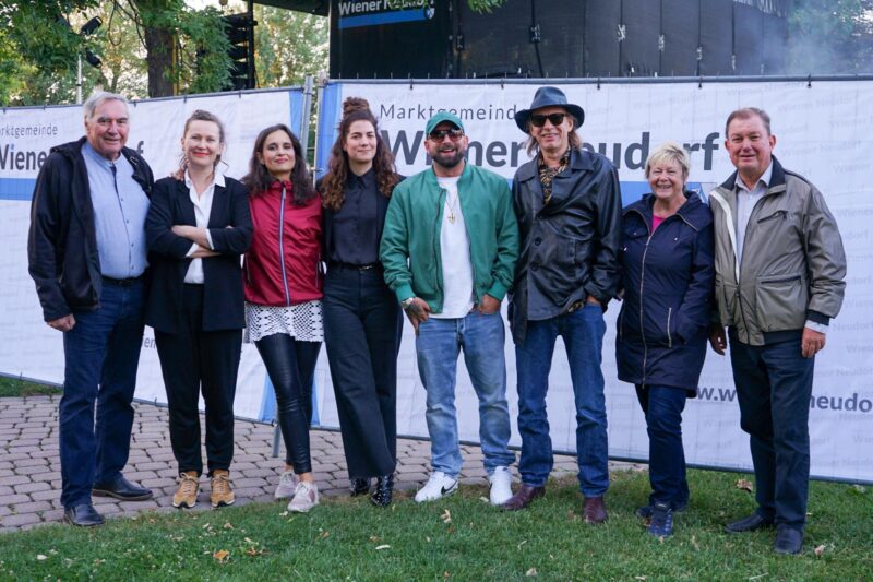 Die Zwidan Zwa Molden und Seiler hinter der Bühne mit dem Frauenorchester, dem Bürgermeister und Niki Patoschka vor dem OPEN AIR 2025 Abschlusskonzert
