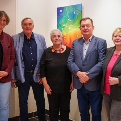 Saxophonist und Sprecher von Even4Sax, neben Niki Patoschka, Sigrid Jonak, Bgm. Herbert Janschka und Gemeinderätin Gaby Janschka vor zwei bunten Bildern der Künstlerin für das Pressefoto