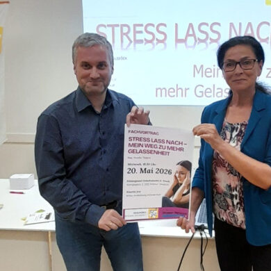 Alexander Bitzan und Mag. Natalie Ölsböck präsentieren das Plakat für den Vortrag im Sitzungssaal